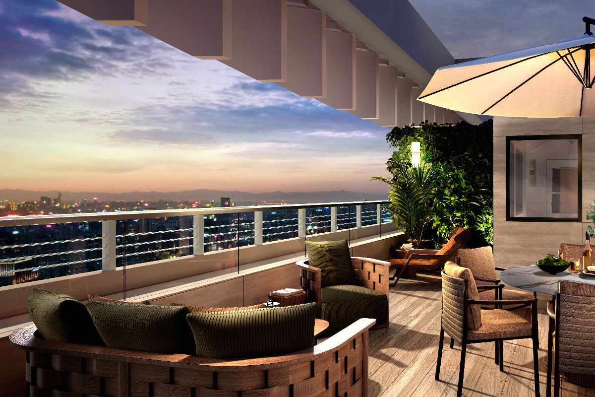 Spacious high-rise balcony with outdoor seating and city views at sunset