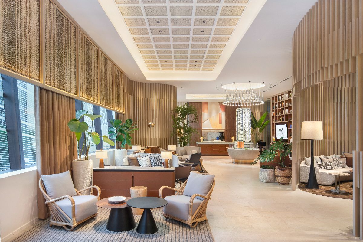 Elegant condominium lounge with warm lighting, indoor plants, and comfortable seating areas