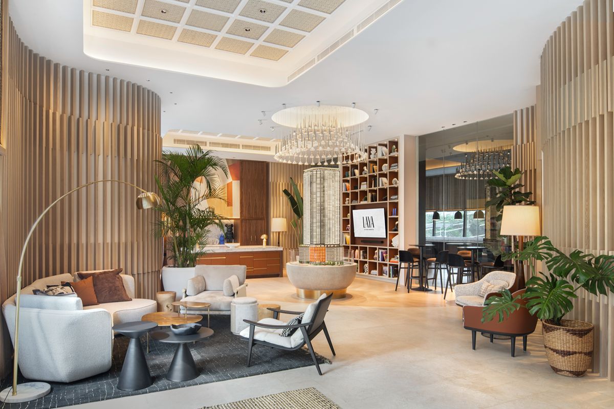 Elegant condominium lounge and concierge area with modern seating, indoor plants, shelving, and refined lighting